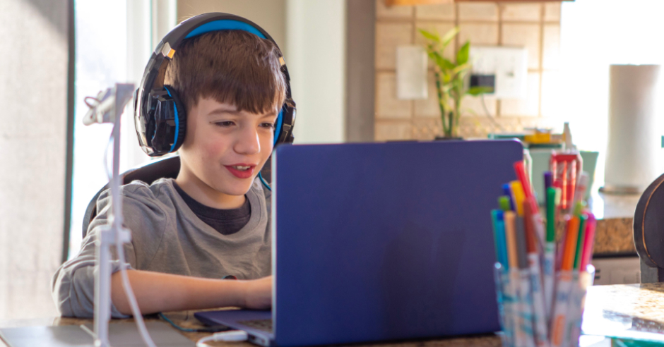 Student with his headphones on taking an online class with his laptop image