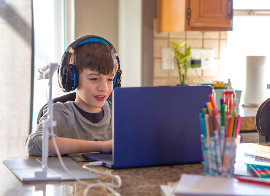 Student with his headphones on taking an online class with his laptop image