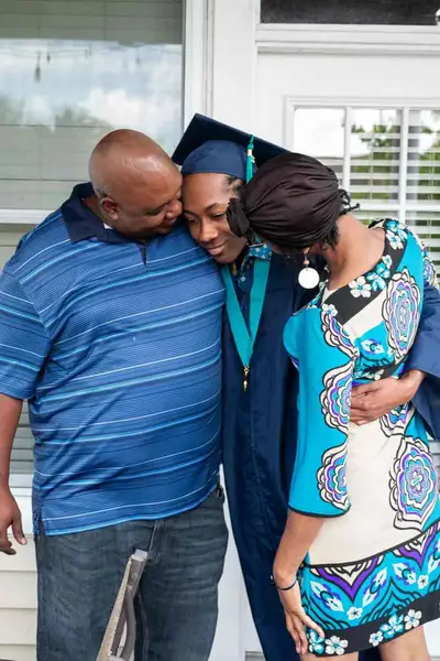 parents hugging their daughter