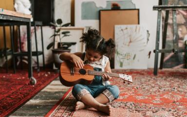 Little girl playing the guitar