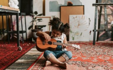 Little girl playing the ukelele
