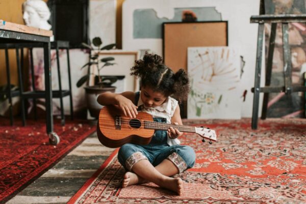 Little girl playing the ukelele